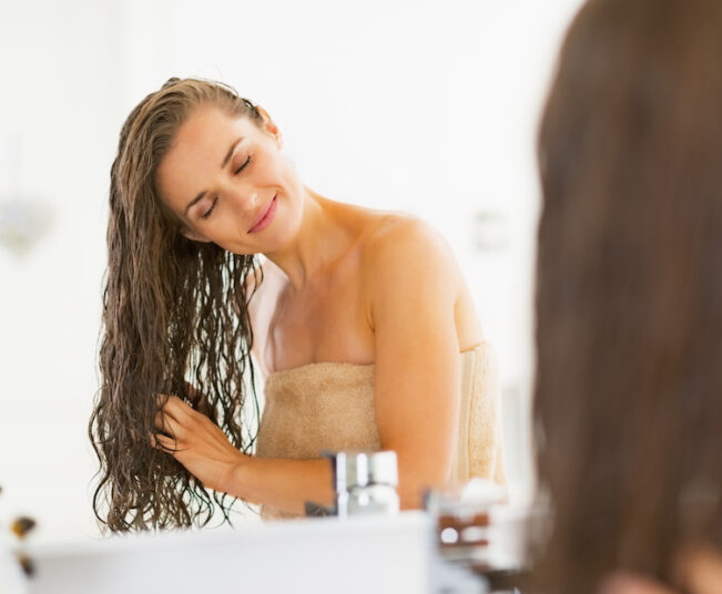 happy young woman with wet hair in bathroom