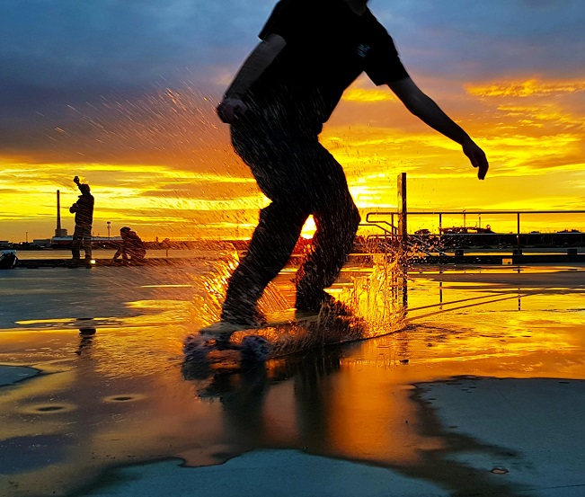 guy cruising through water with e-board