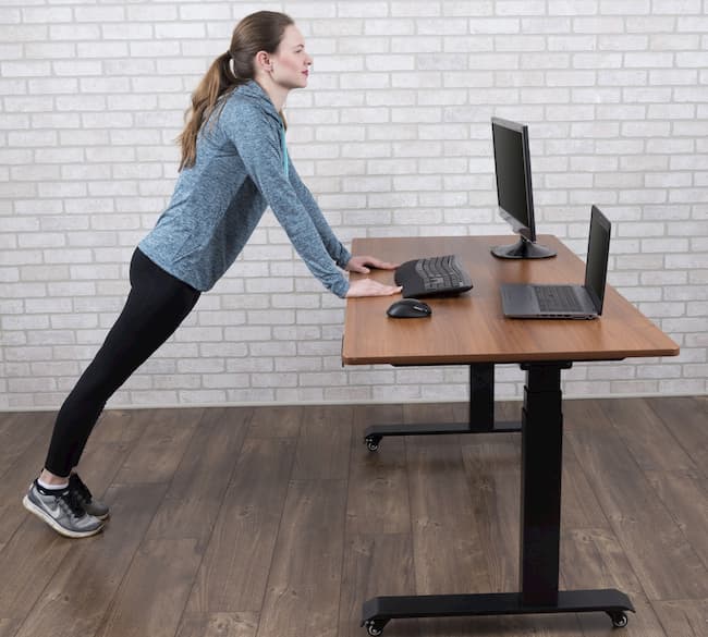 girl stretching while working ona standing desk