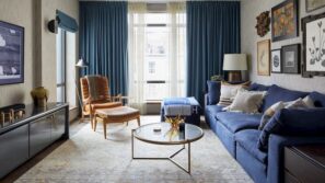 modern living room with leather armchair blue sofa bed with decorative pillows coffee table blue cutains and artwork on the wall