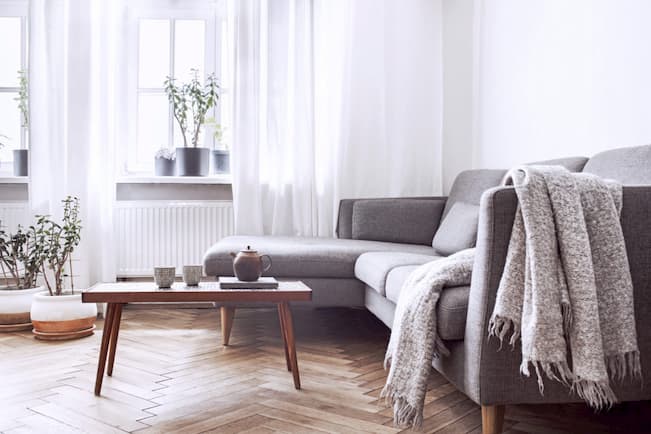 living room with sofa bed throw blanket and coffee table