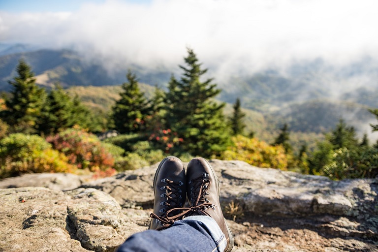 picture of a person sitting on a cliff in the woods 