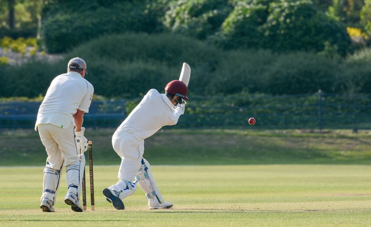 two men playing cricket outside