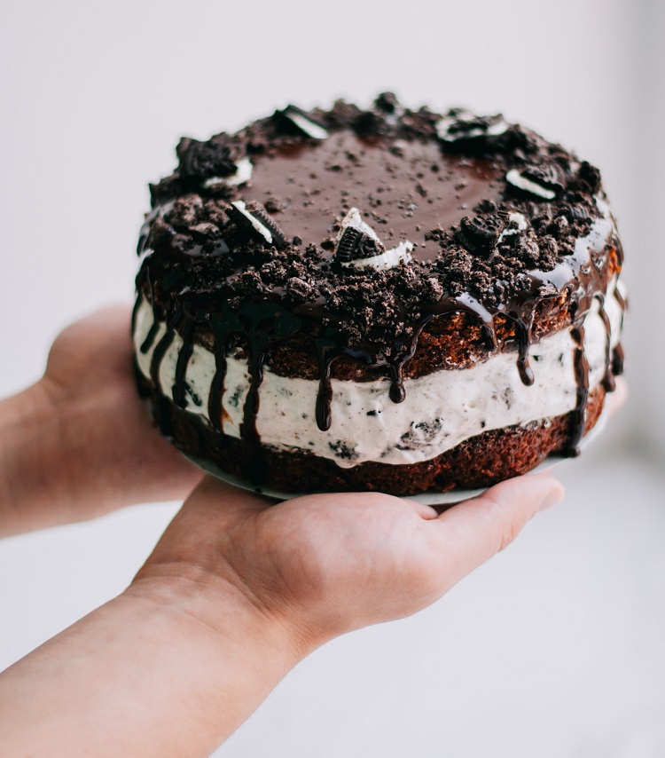 hands holding chocolate cake 