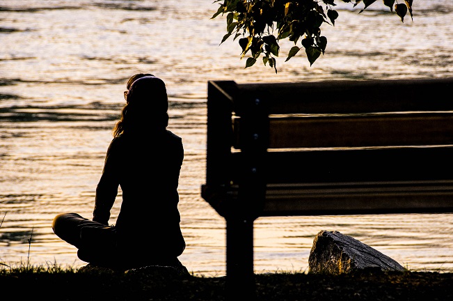 picture of a person relaxing by water 