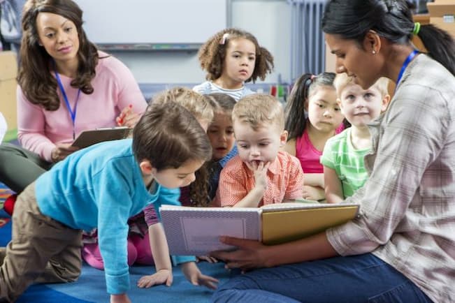 Teacher reading to children from the books