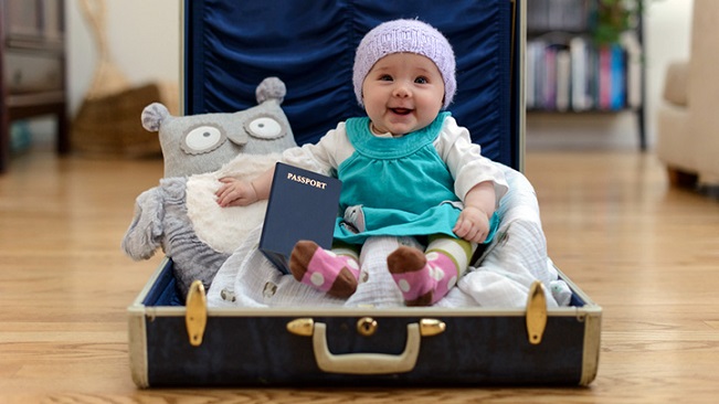 out and about baby with stuffed animal in suitcase 