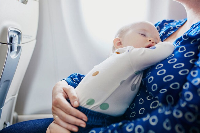 out and about baby sleeping on mom on a plane