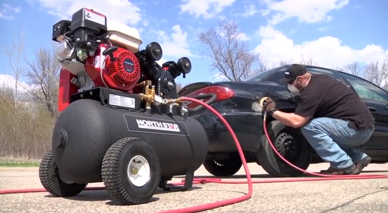 Man working with portable petrol air compressor