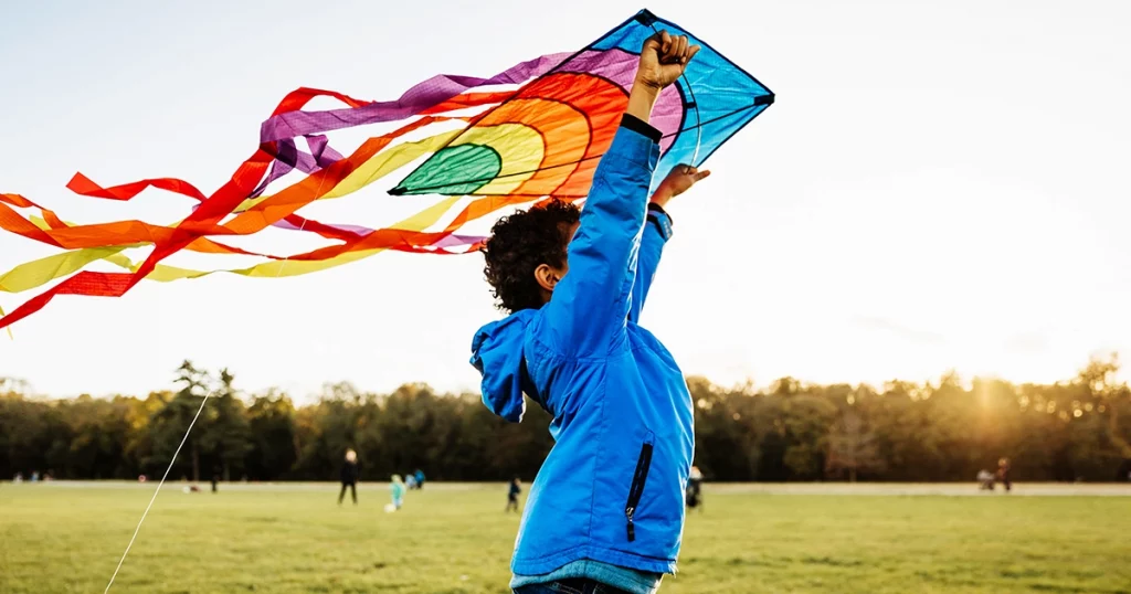 kid flying kite as fun inflatable toy