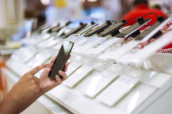 holding refurbished phone in a store