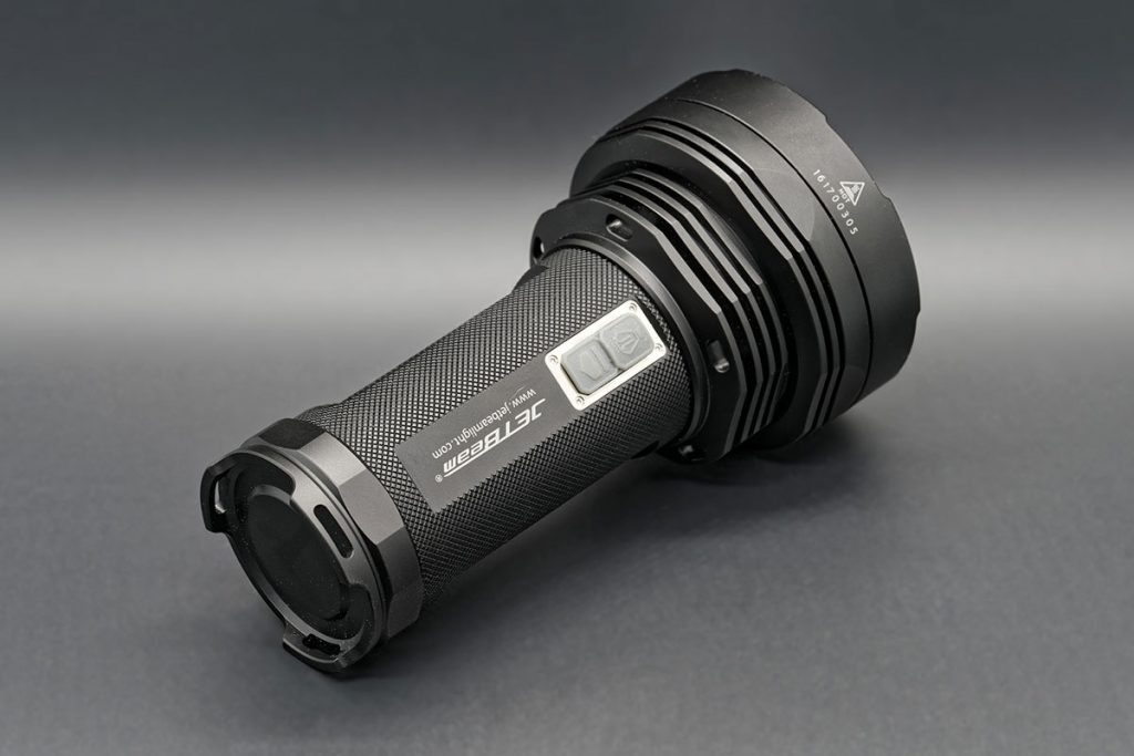 JetBeam T6 flashlight on grey background