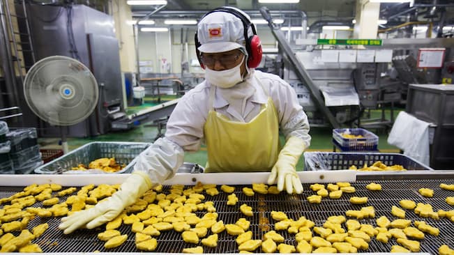Worker producing chicken nuggets