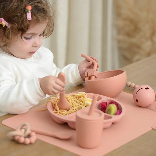 picture of a toddler using its oun tableware