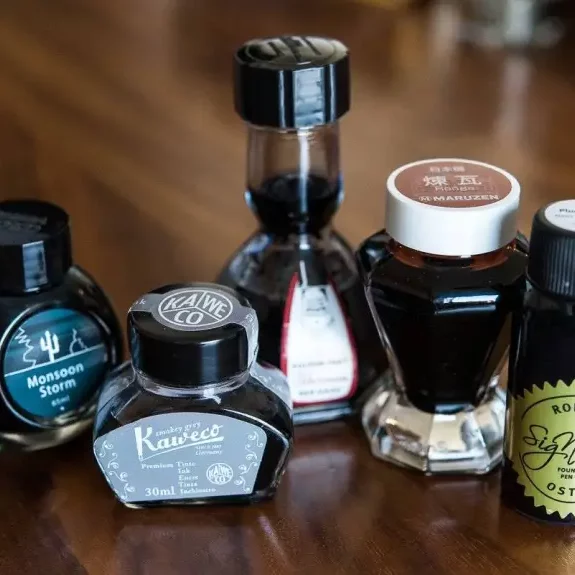 Fountain pen ink bottles on to wooden table
