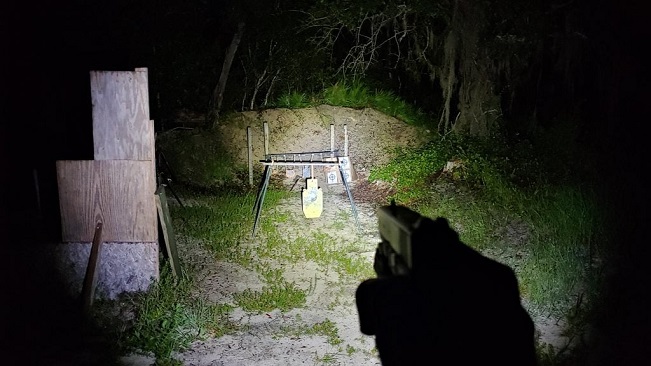 pistol light illuminating target at night