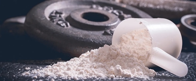 a scoop of pre-workout powder on a weight plate 