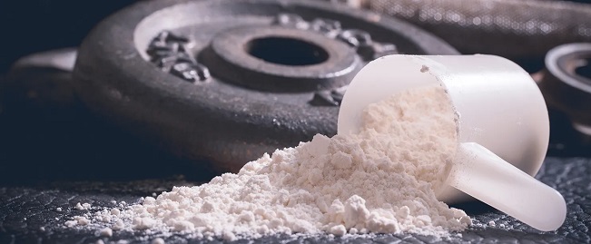 a scoop of pre-workout powder on a weight plate
