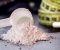 a scoop of pre-workout powder, measuring ape and capsules on a table