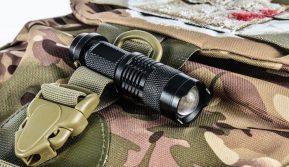 tactical flashlight on military backpack