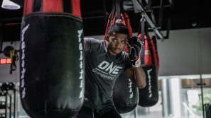 MMA fighter practicing with a punching bag in a gym