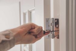 a person using a tool to tighten up the butt hinge