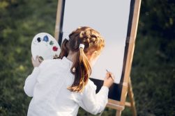 Cute little girl painting on a canvas